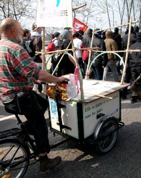 Contre-sommet de l'OTAN à Strasbourg, avril 2009 : militant pacifiste à vélo entouré de cagoules noires